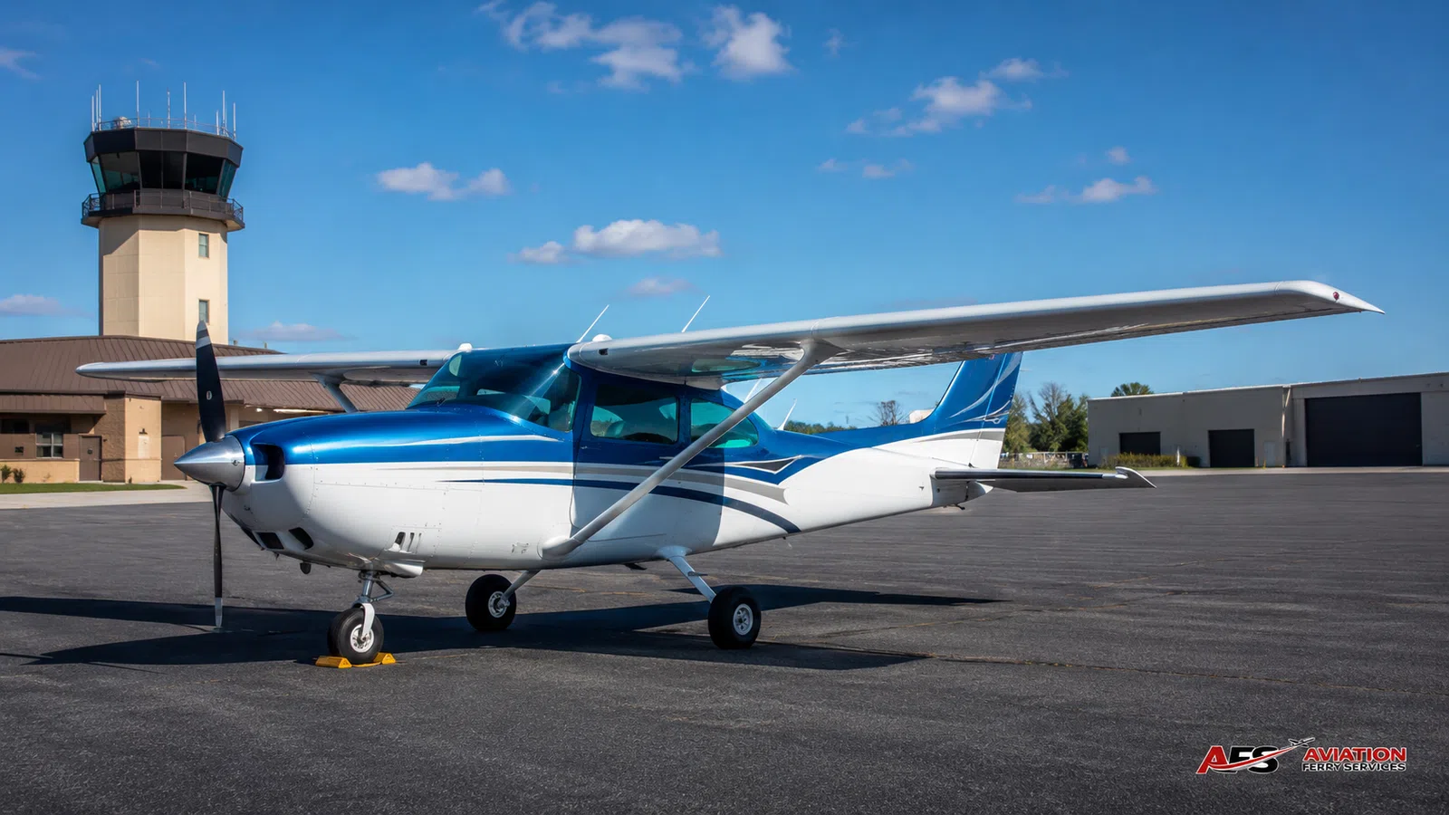 AFS aircraft photo — high-wing aircraft near hangar