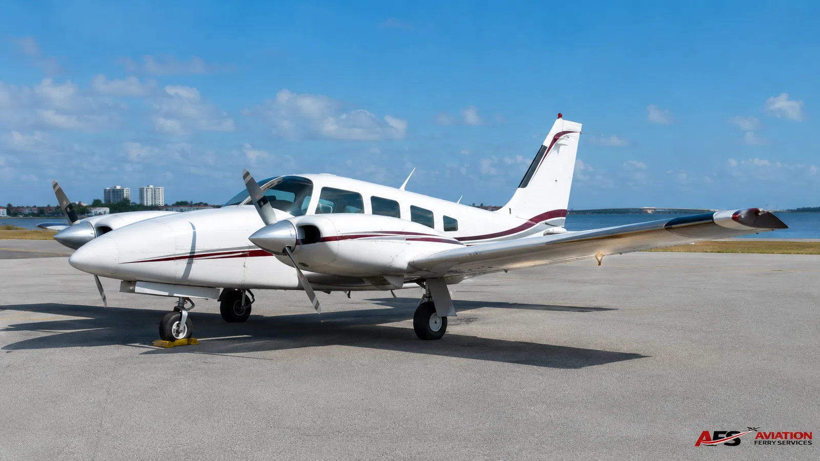 Twin-engine piston aircraft parked on an airport ramp.